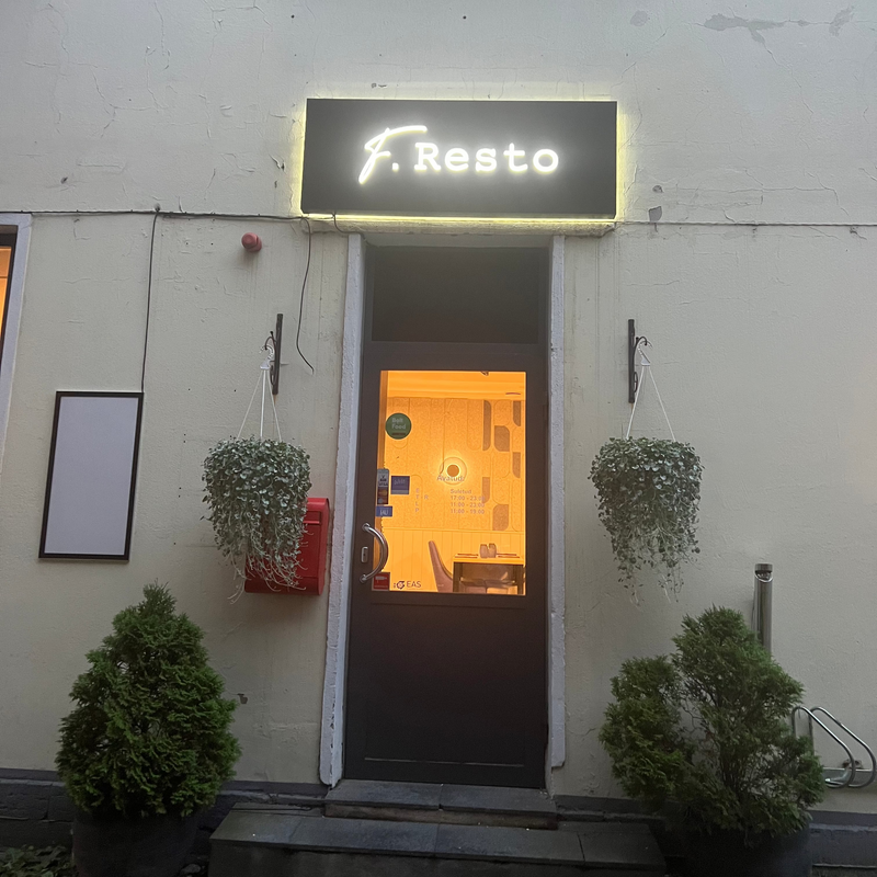 Restaurant entrance with 'f. Resto' sign and illuminated door